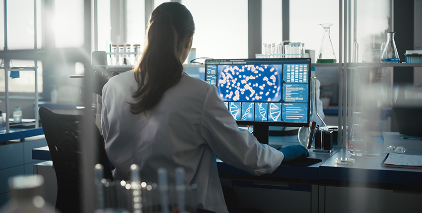 A person sits at a computer in a laboratory