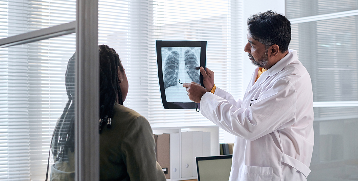 Patient reviews chest x-ray with doctor. -- health equity coverage from STAT