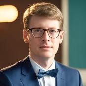 Portrait photo of Brad Crotty, wearing glasses and looking into camera